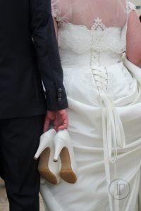 novio llevando los zapatos de la novia en su boda